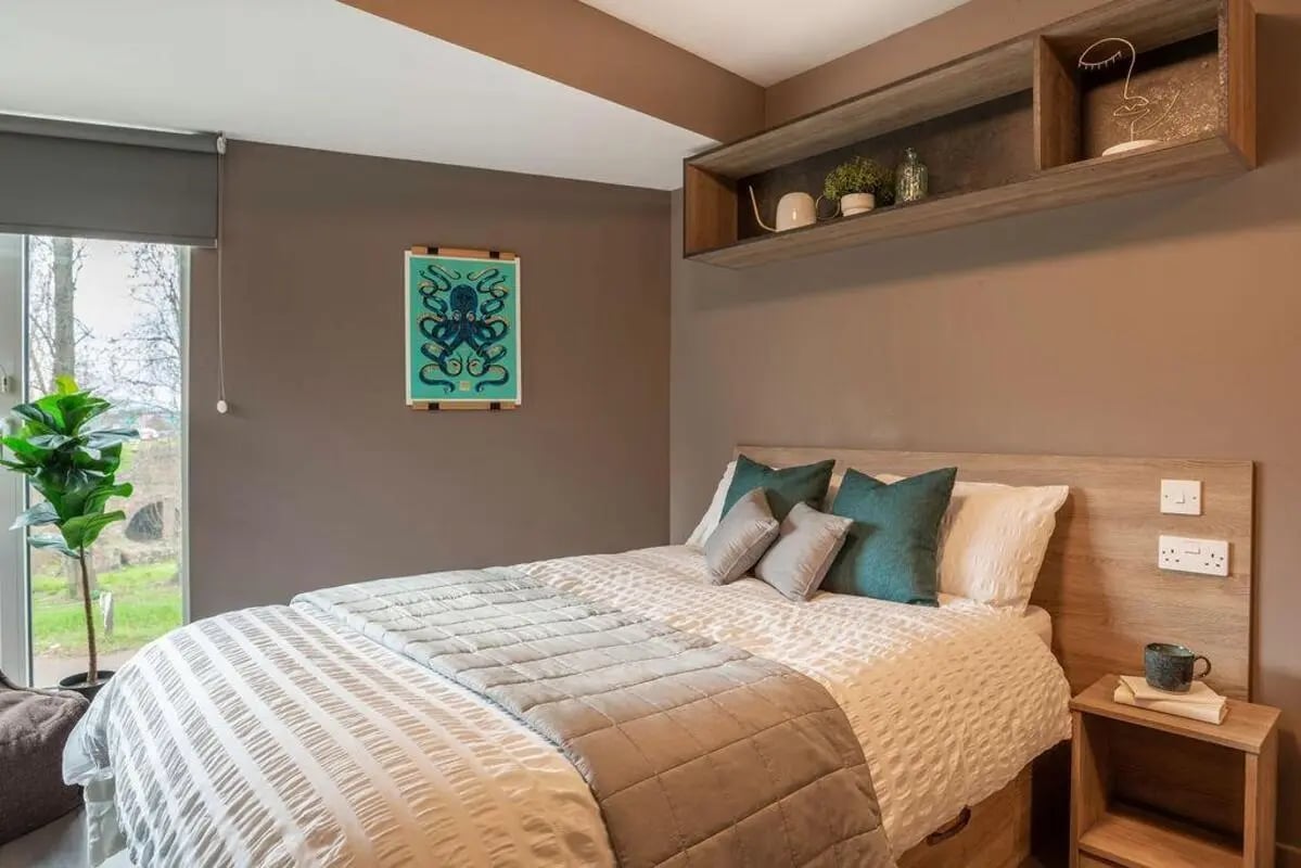 Bed with teal pillows octopus art shelf bedroom at West Gate in Exeter Student Accommodation