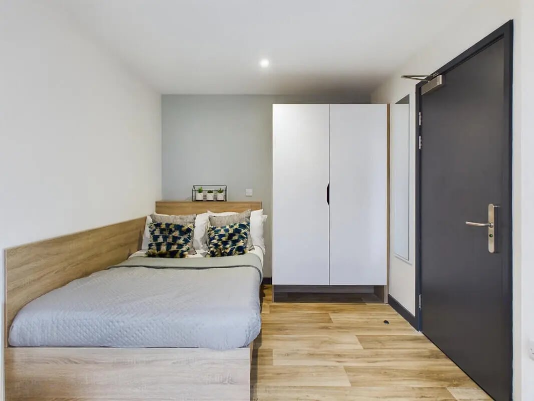 Bed with pillows wardrobe and door bedroom at Eden Square in Coventry Student Accommodation