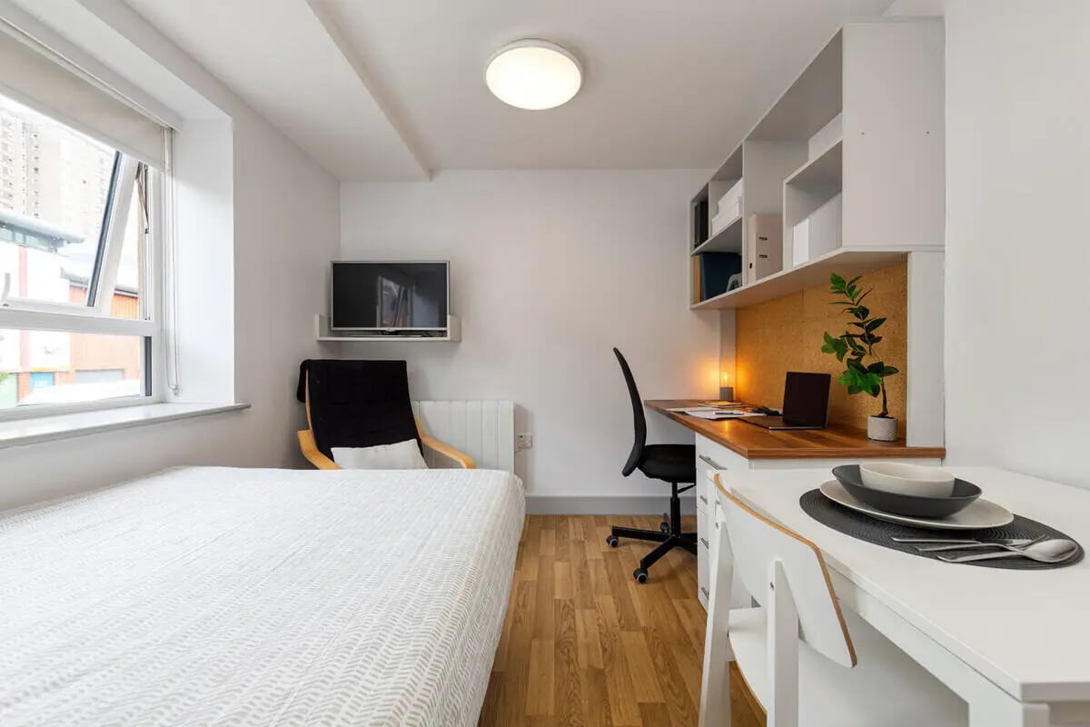 Bed desk chair shelving and TV student room at Collegiate St James Street in Portsmouth Student Accommodation