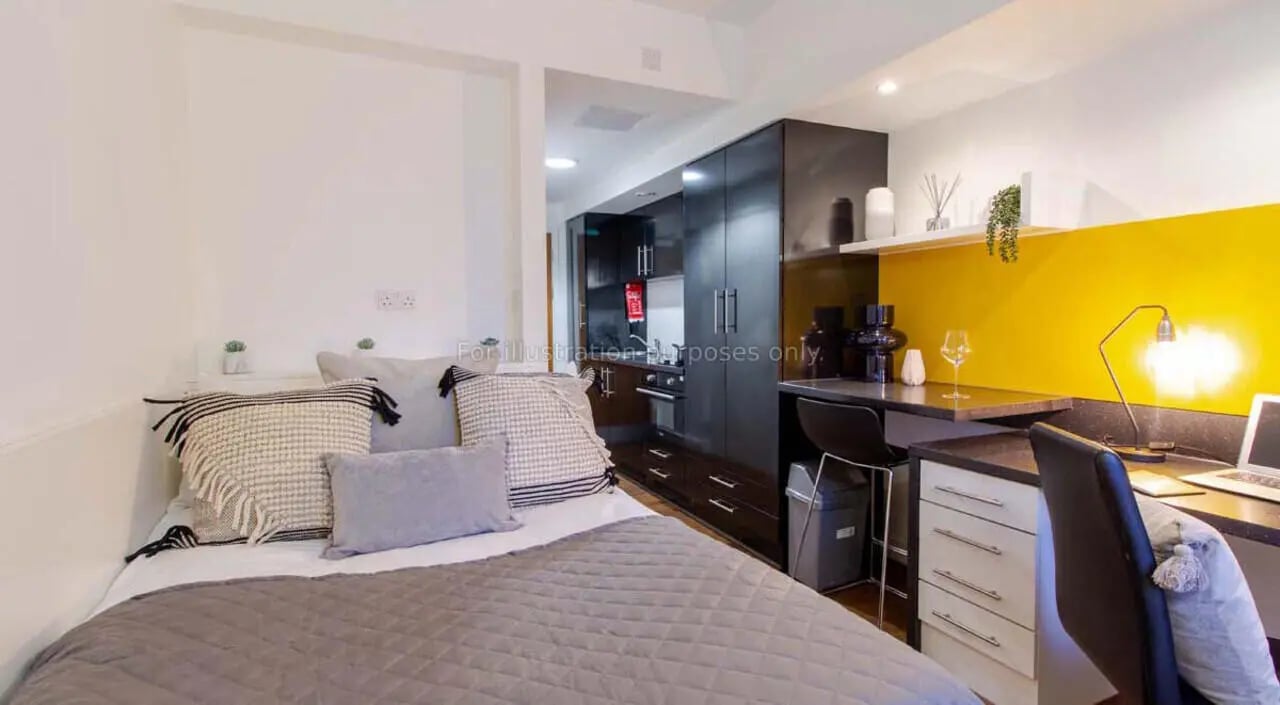 Bed desk kitchen cabinets and yellow wall studio at Bowman House in Nottingham Student Accommodation