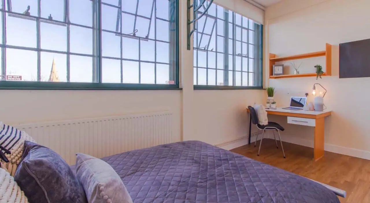 Bed with desk and large windows bedroom at Nottingham Square in Nottingham Student Accommodation