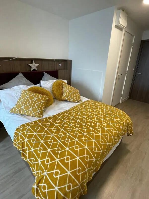 Bed with yellow patterned blanket and pillows bedroom at Phoenix Place in Liverpool Student Accommodation