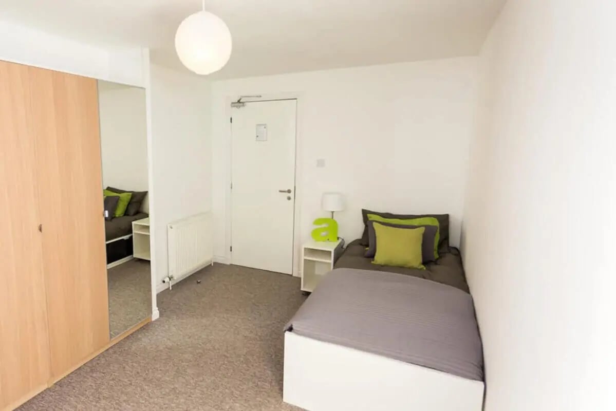 Wardrobe bed nightstand lamp and pillows bedroom at Froghall in Aberdeen Student Accommodation