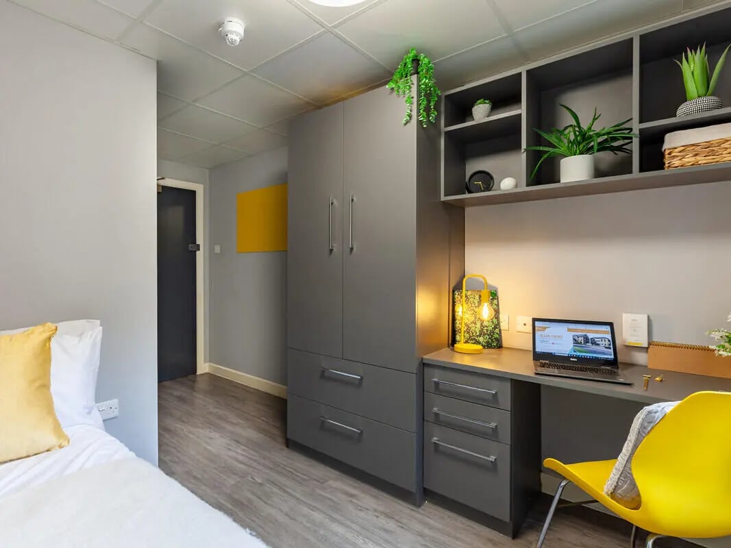 Desk wardrobe plants and laptop bedroom study area at Allen Court in Manchester Student Accommodation