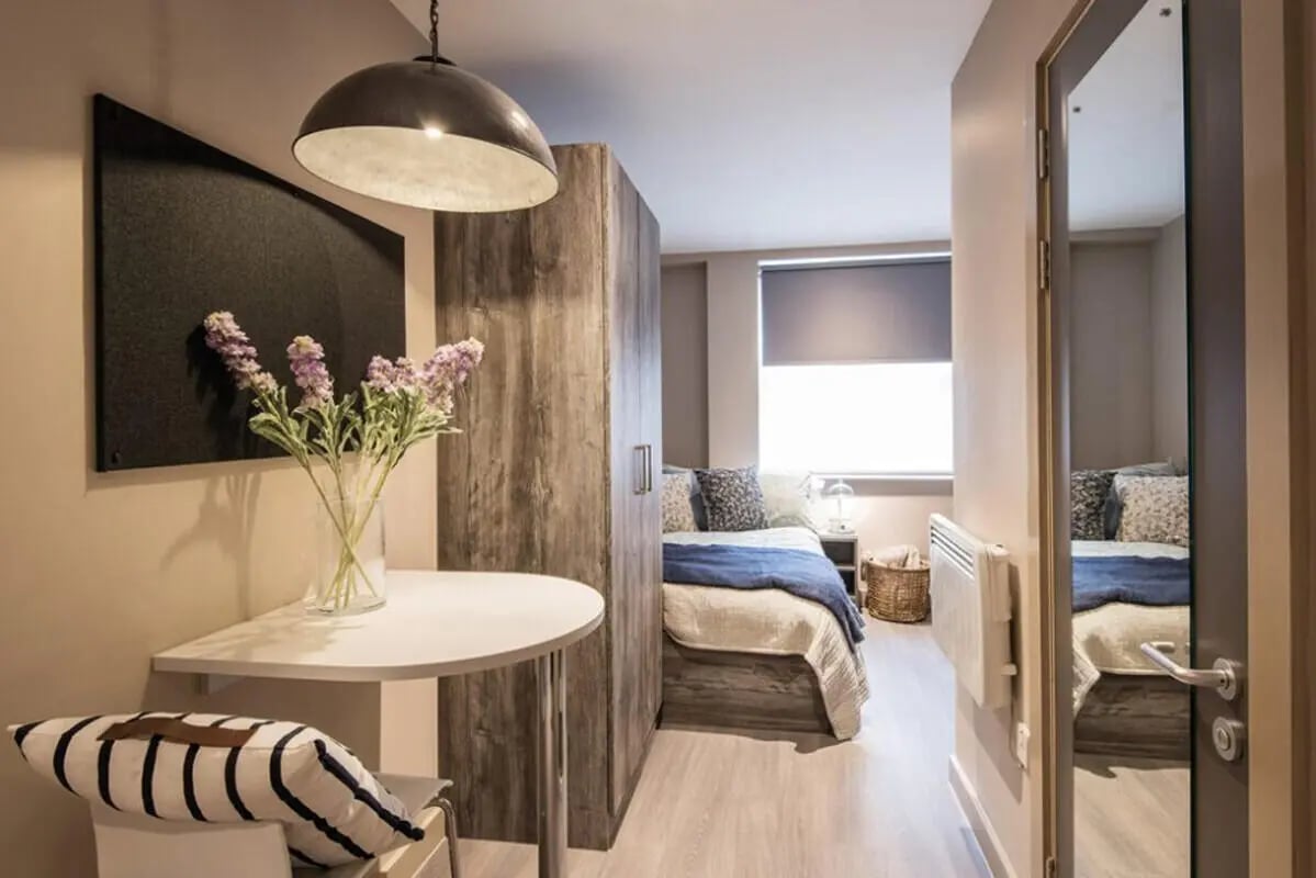 Table vase flowers bed wardrobe window bedroom at Collegiate Roman House in Derby Student Accommodation