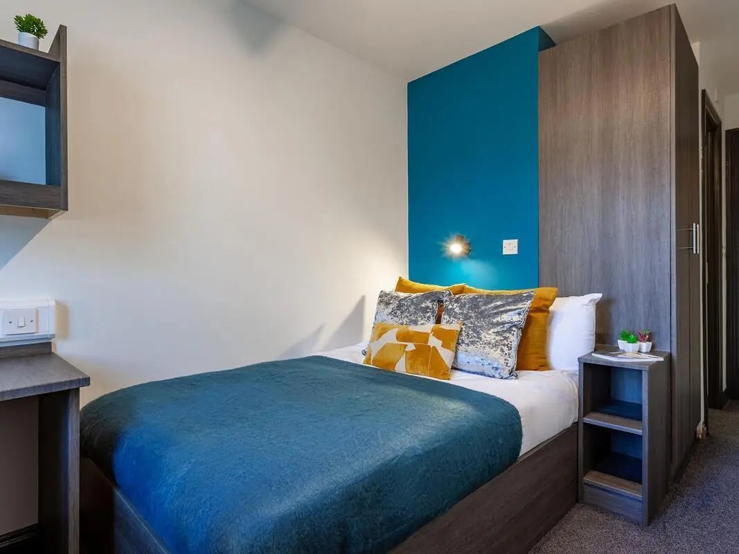 Bed with pillows and blue blanket bedroom at Trinity Student Village in Preston Student Accommodation