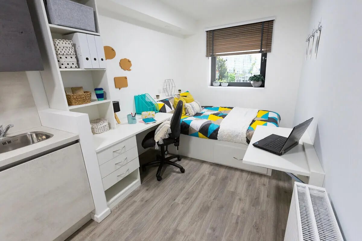 Bed desk sink storage and laptop bedroom at Westcombe House in London Student Accommodation