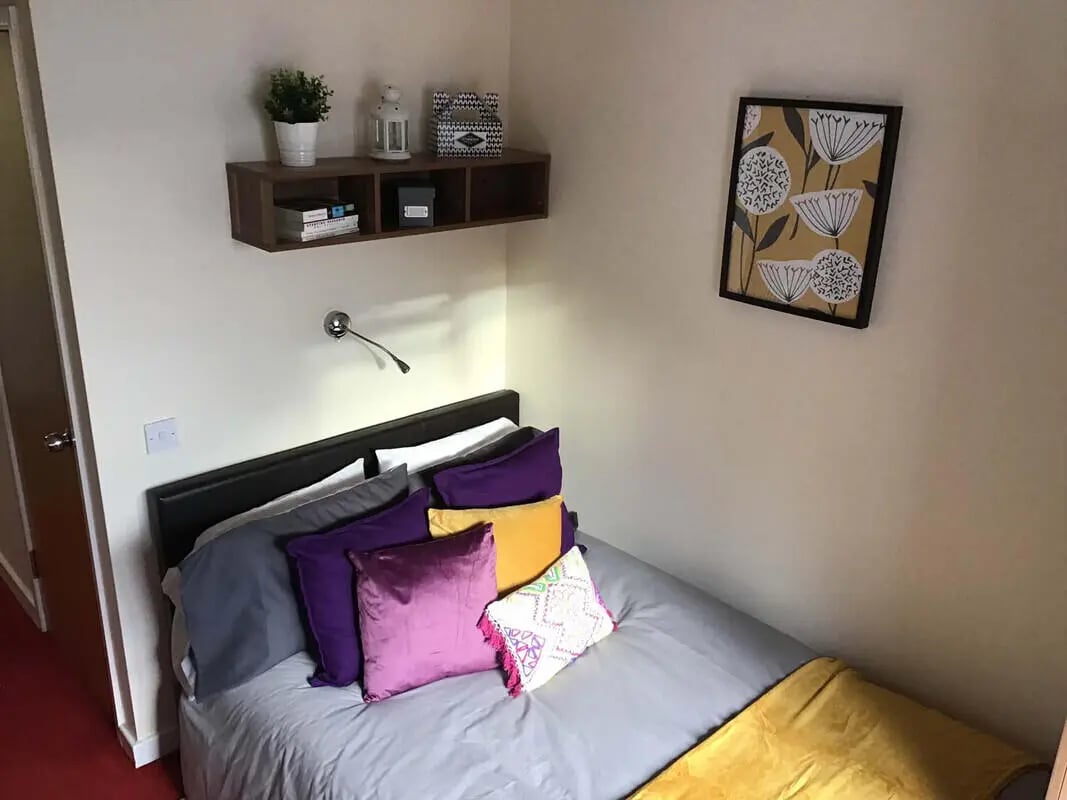 Bed with colorful pillows and artwork bedroom at Canterbury Student Village in Canterbury Student Accommodation