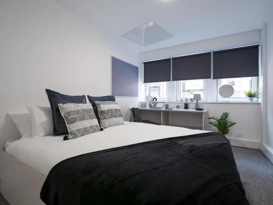 Bed with pillows and desk with laptop bedroom at The Paper Works in Sheffield Student Accommodation