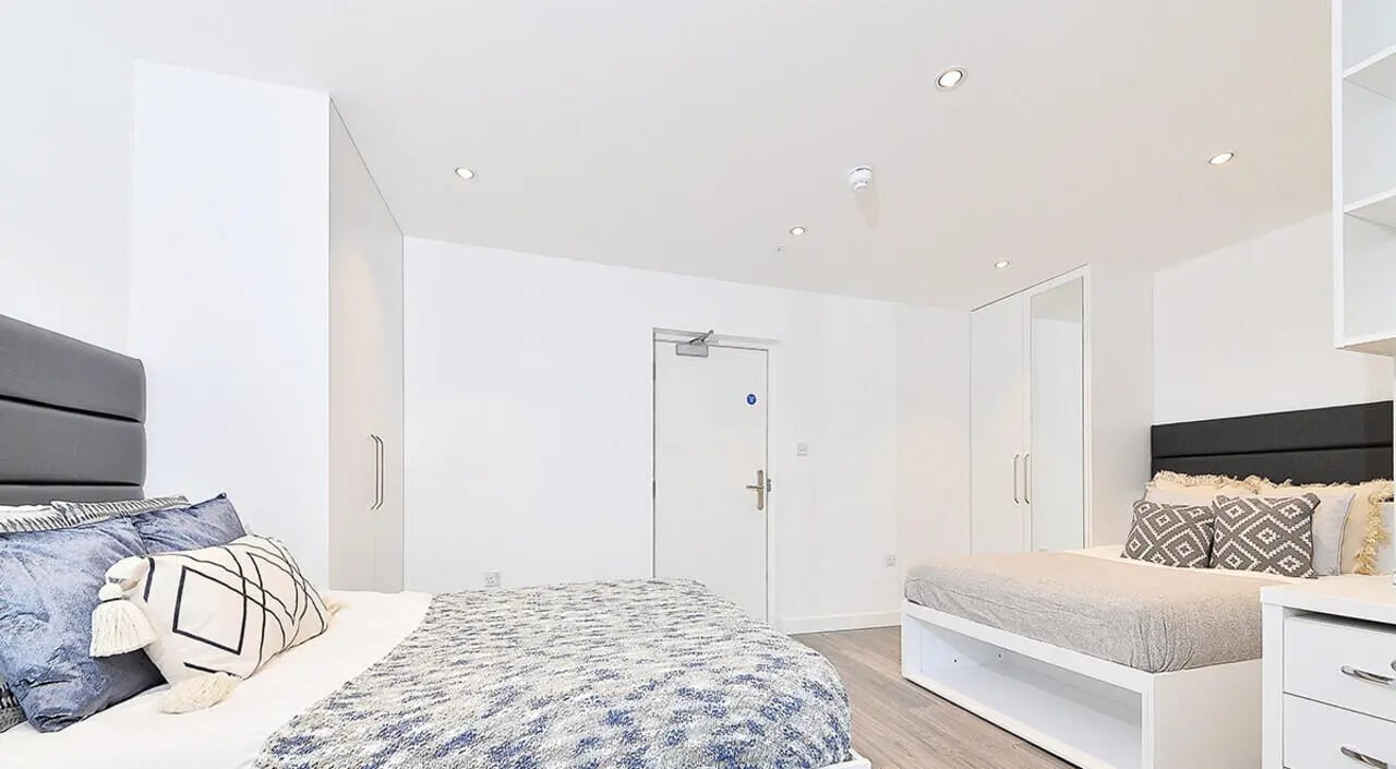 Two beds with patterned throws and pillows bedroom at Miura in Nottingham Student Accommodation