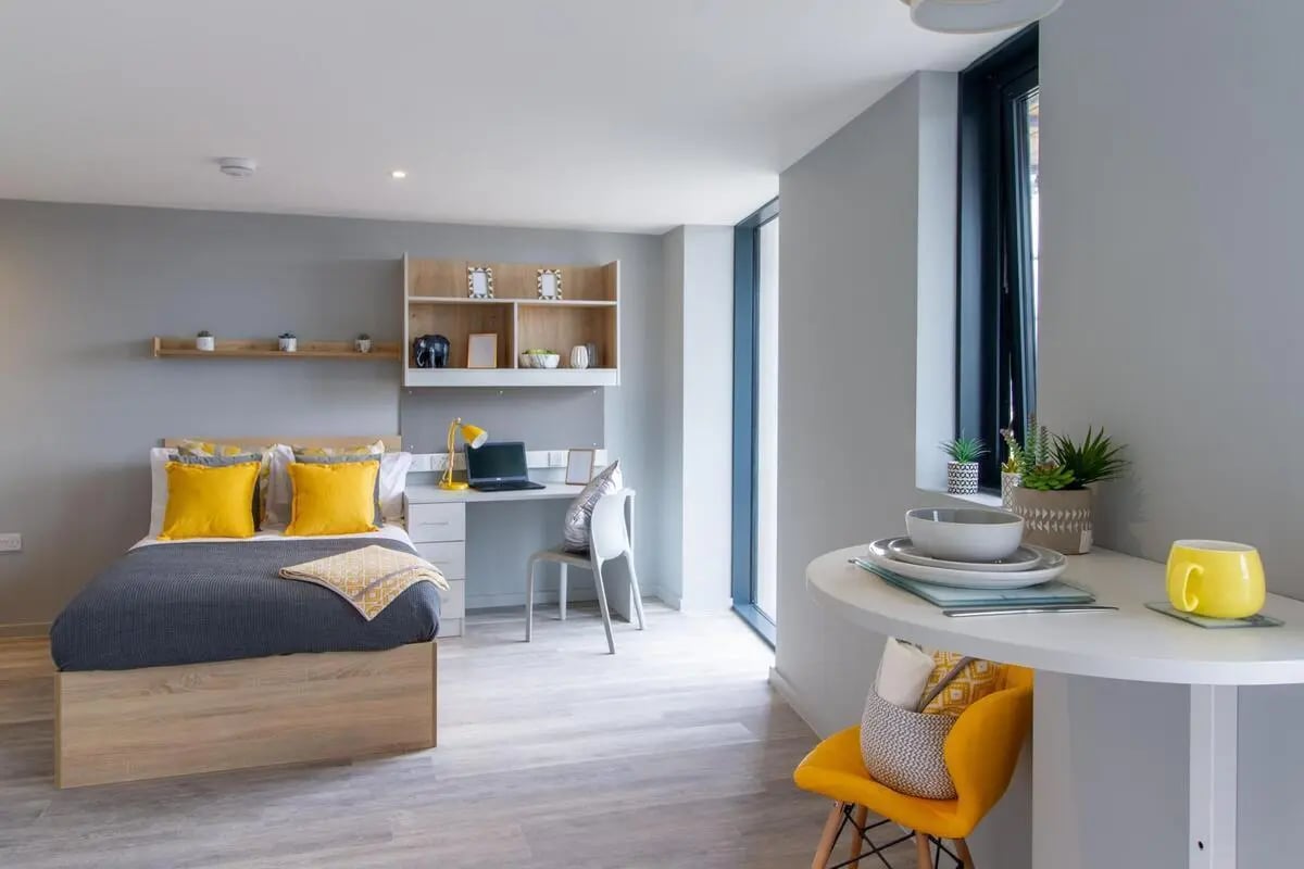 Bed desk shelving and round table bedroom at Renslade House in Exeter Student Accommodation