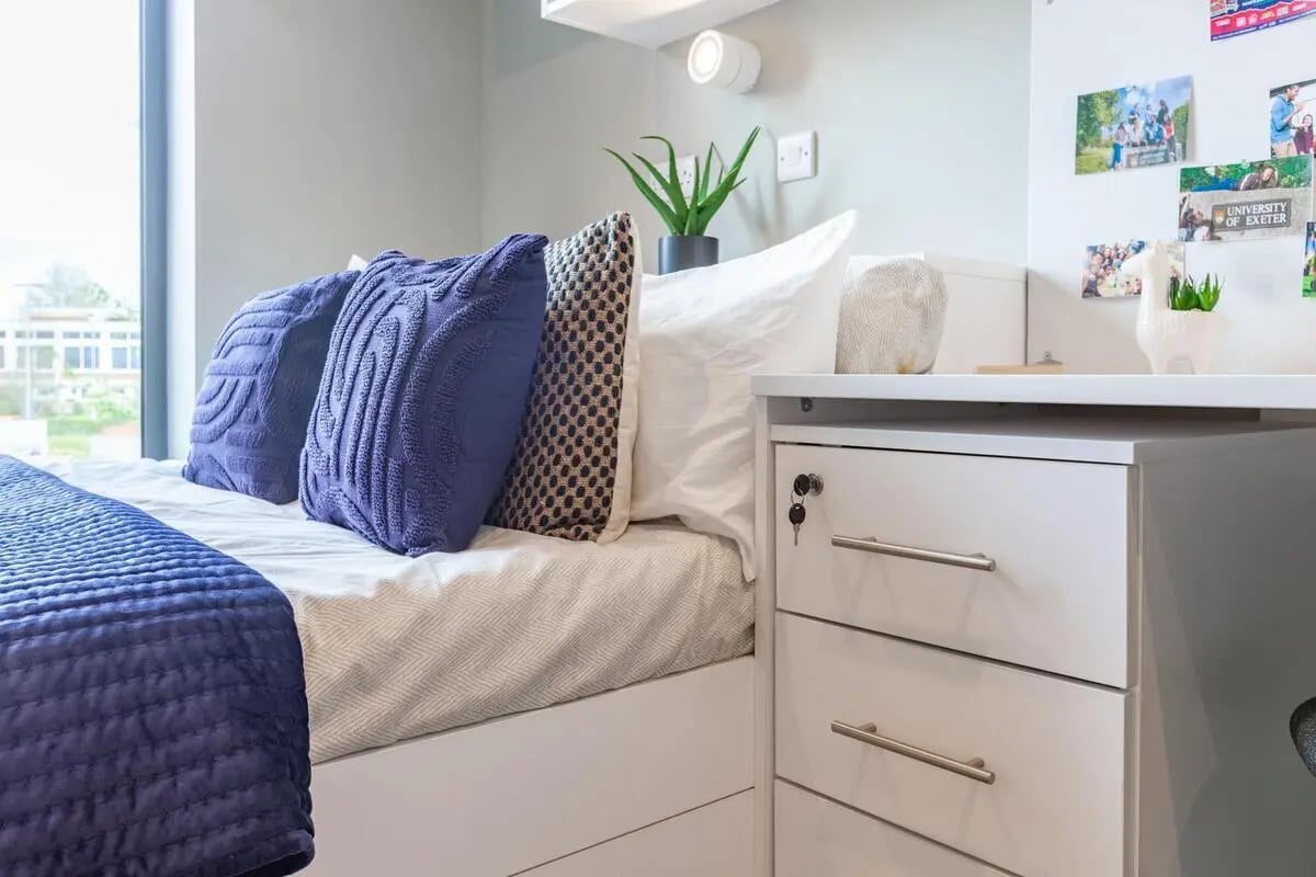 Bed with blue pillows and white desk Bedroom at Atlas House in Exeter Student Accommodation