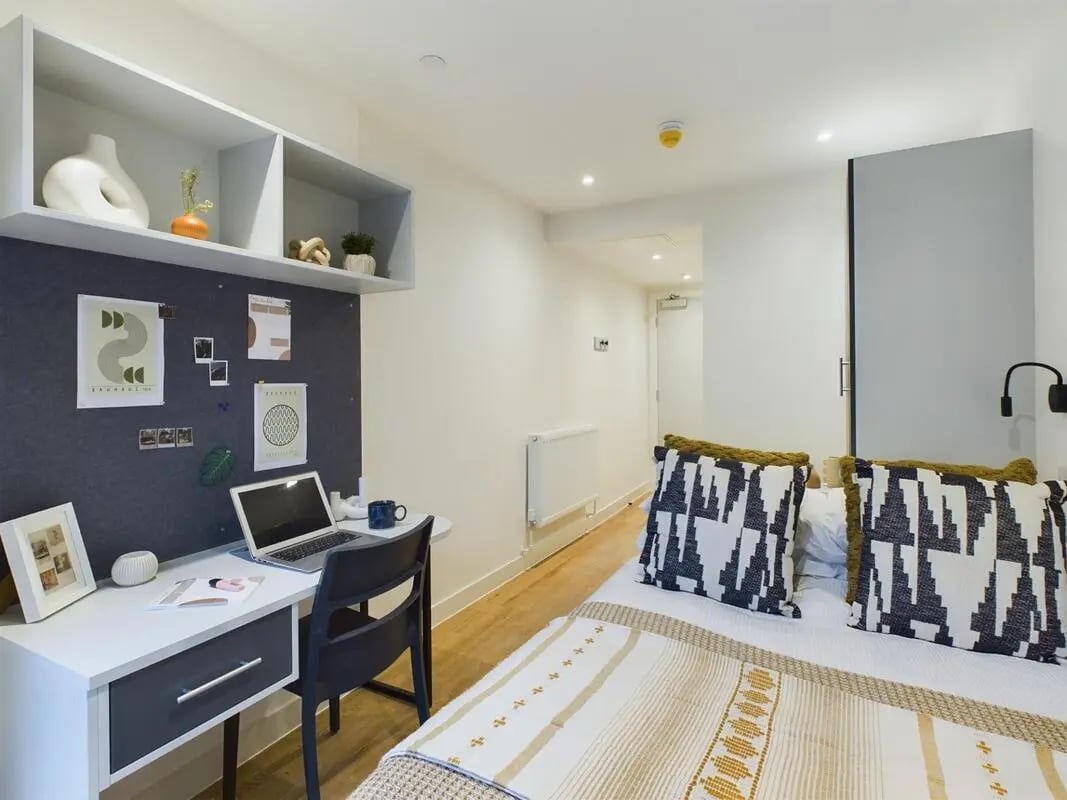Desk bed shelves and pillows bedroom at Raffles Hall in York Student Accommodation