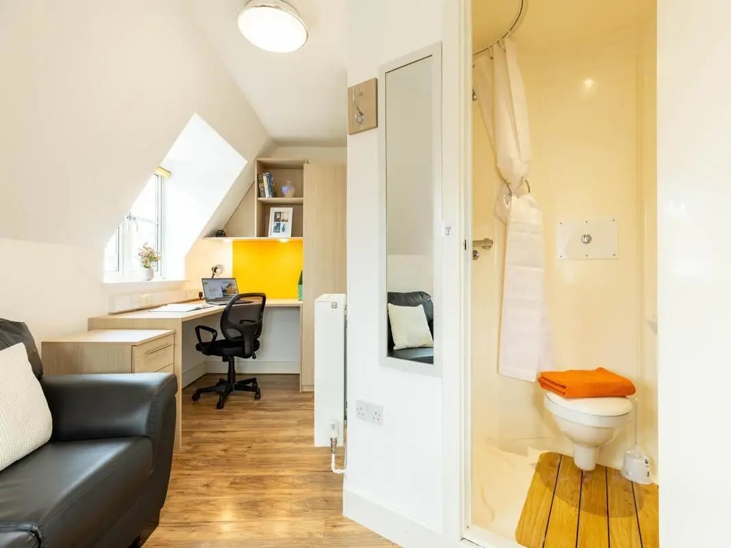 Desk chair sofa and bathroom shower room. at Iron Bridge Studios in Exeter Student Accommodation
