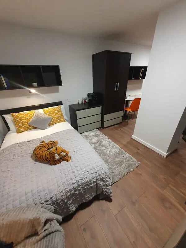 Bed with tiger plush grey rug wooden floor bedroom at Plato House in Liverpool Student Accommodation
