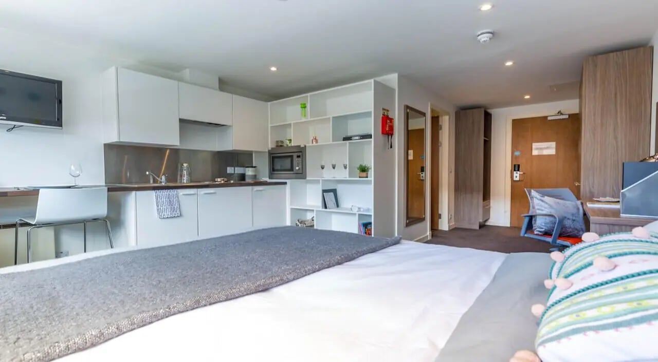Studio apartment with kitchen bed and chair. at Gallery Apartments in Glasgow Student Accommodation