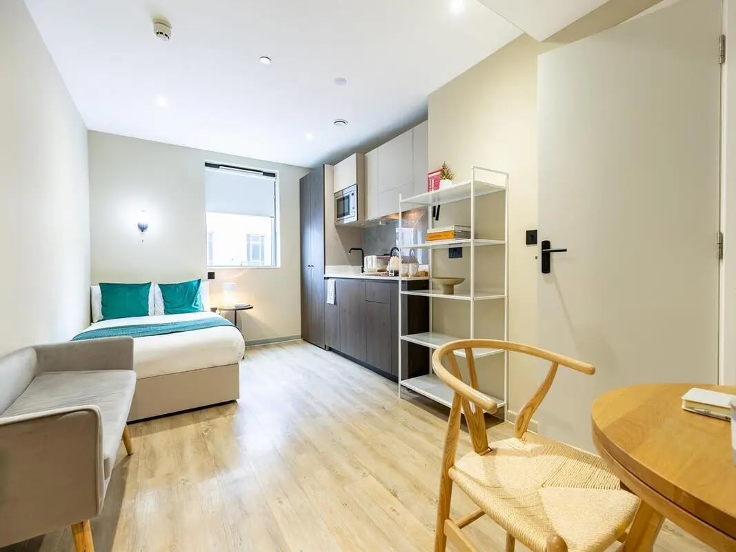 Bed couch kitchen shelving and chair studio apartment at Tribu Kingston in Kingston Upon Thames Student Accommodation