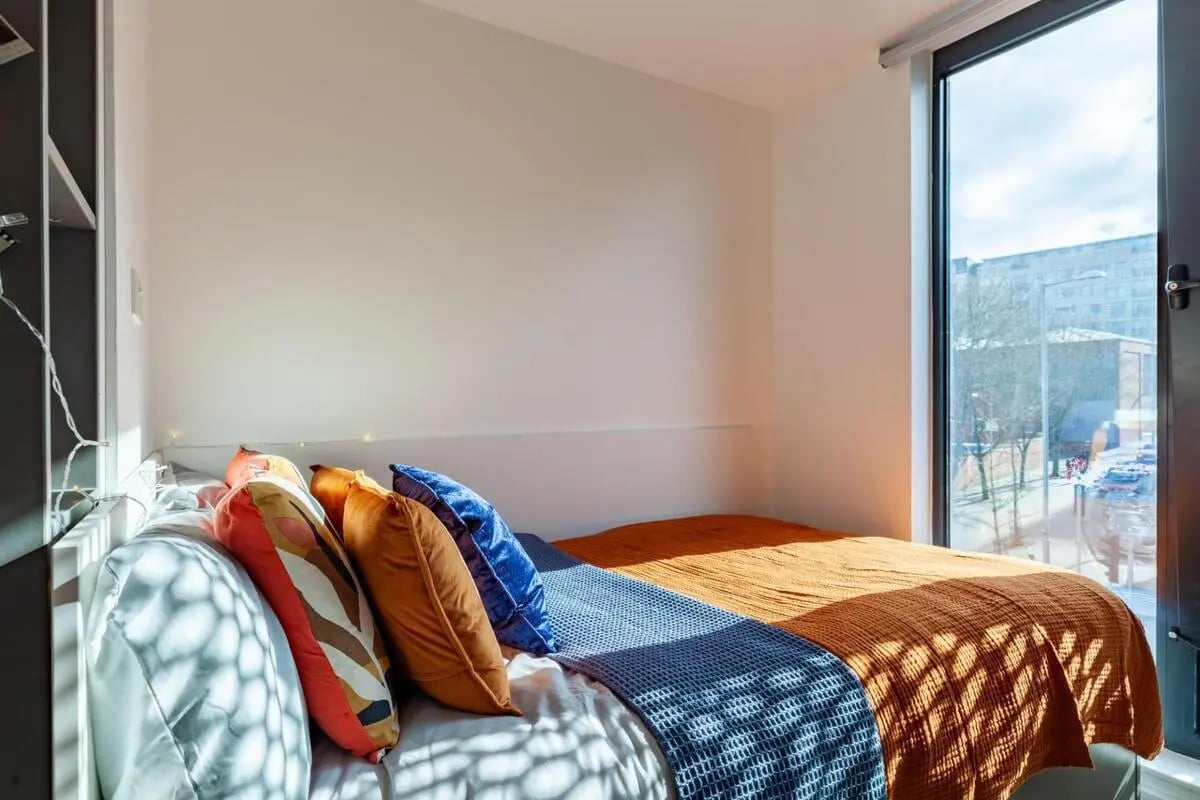 Bed with pillows and blankets window view bedroom at Medici in Nottingham Student Accommodation