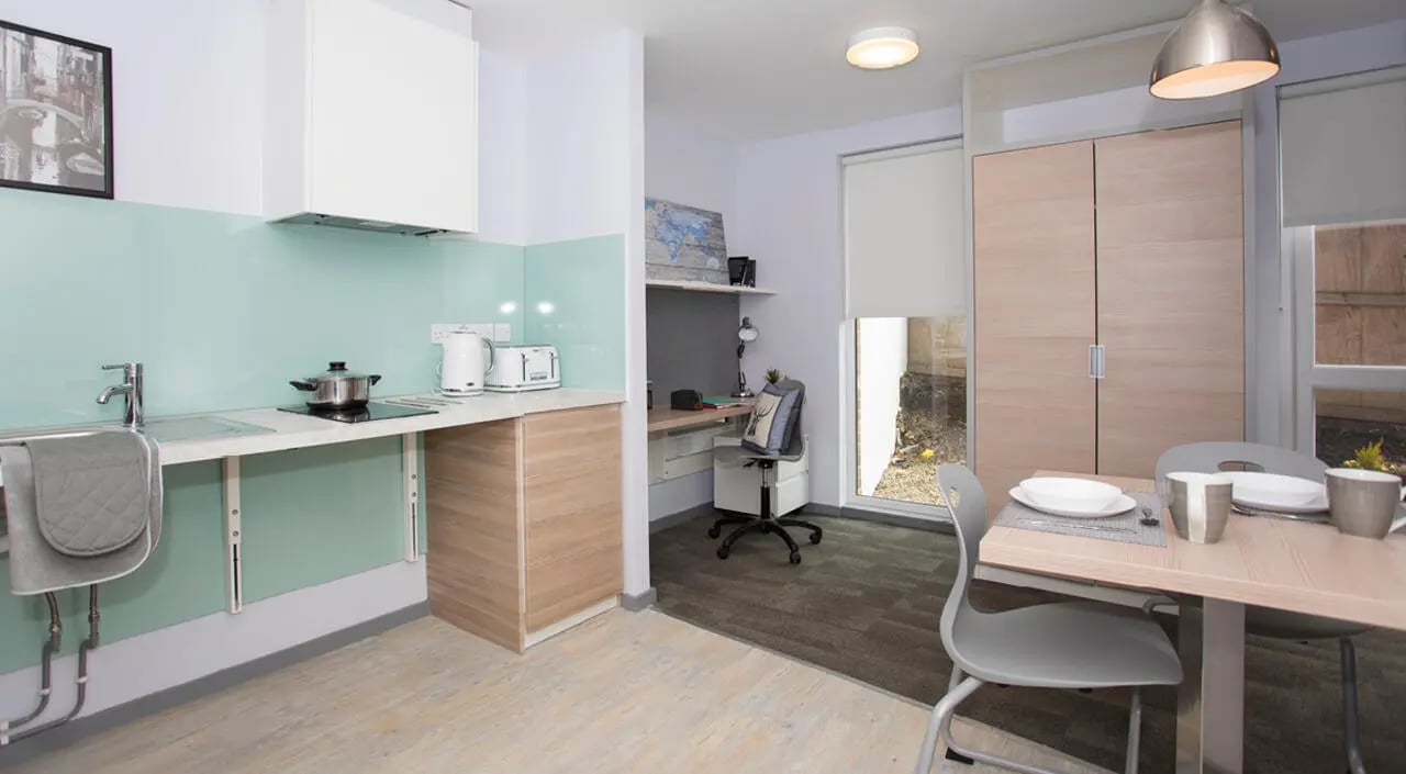 Kitchen sink stove toaster desk chairs dining table kitchen at Duresme Court in Durham Student Accommodation