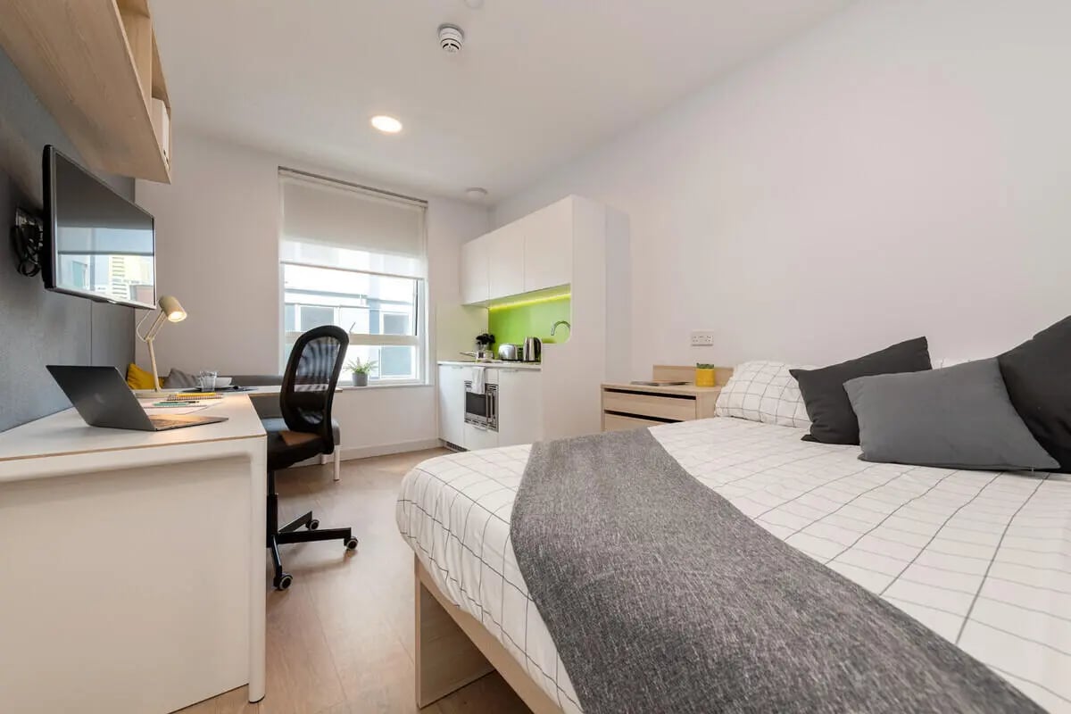 Bed desk kitchen appliances and window studio apartment at Collegiate Middle Street in Portsmouth Student Accommodation