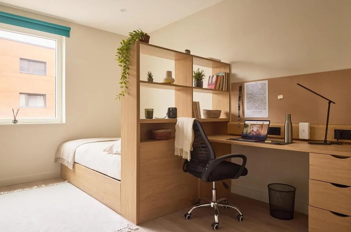 Bed desk chair shelves lamp room interior at Ark Canning Town in London Student Accommodation