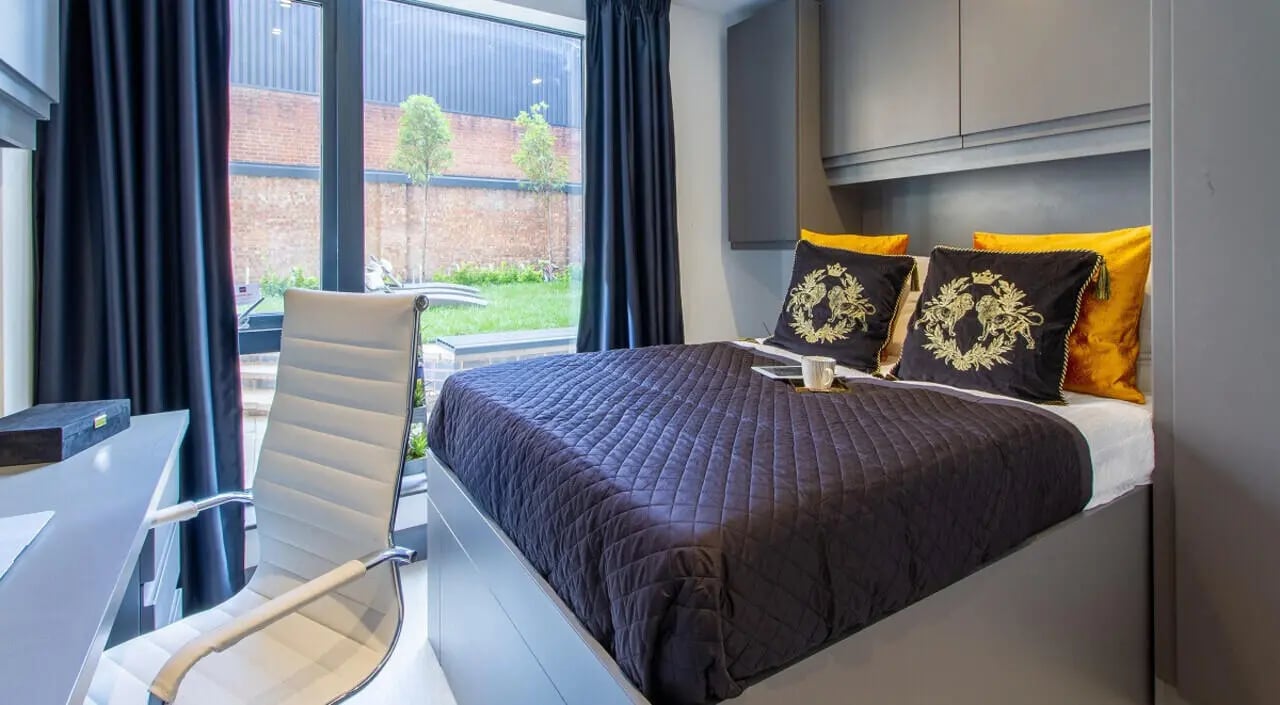 Bed with decorative pillows and desk with chair bedroom at 33 Parkside in Coventry Student Accommodation