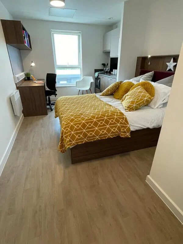 Bed desk chair and kitchen area studio apartment at Phoenix Place in Liverpool Student Accommodation