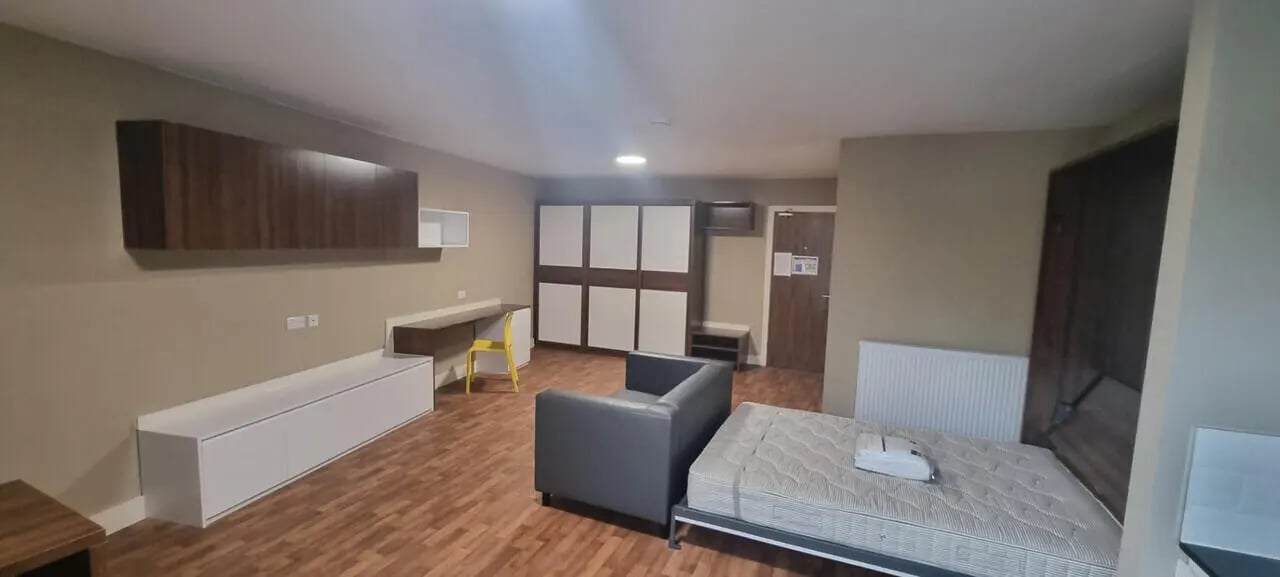 Bed desk armchair wardrobes white cabinets room at Pembroke Studios in Liverpool Student Accommodation