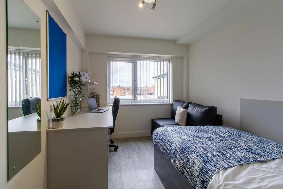 Desk sofa bed with blue blanket bedroom at Dover Street Apartments in Leicester Student Accommodation