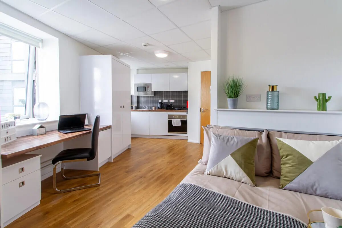 Desk laptop kitchen and bed living area at Danesgate House in Lincoln Student Accommodation
