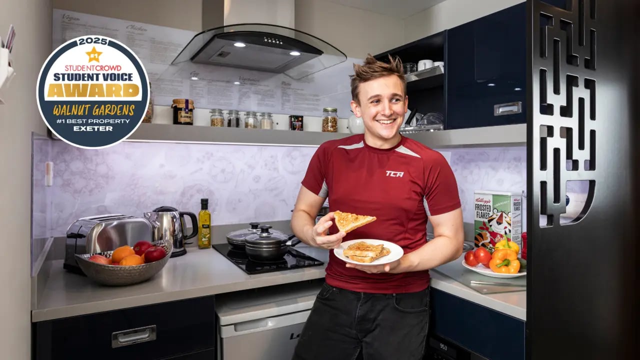 Man with toast in modern student accommodation kitchen at Study Inn Walnut Gardens Exeter in Exeter Student Accommodation