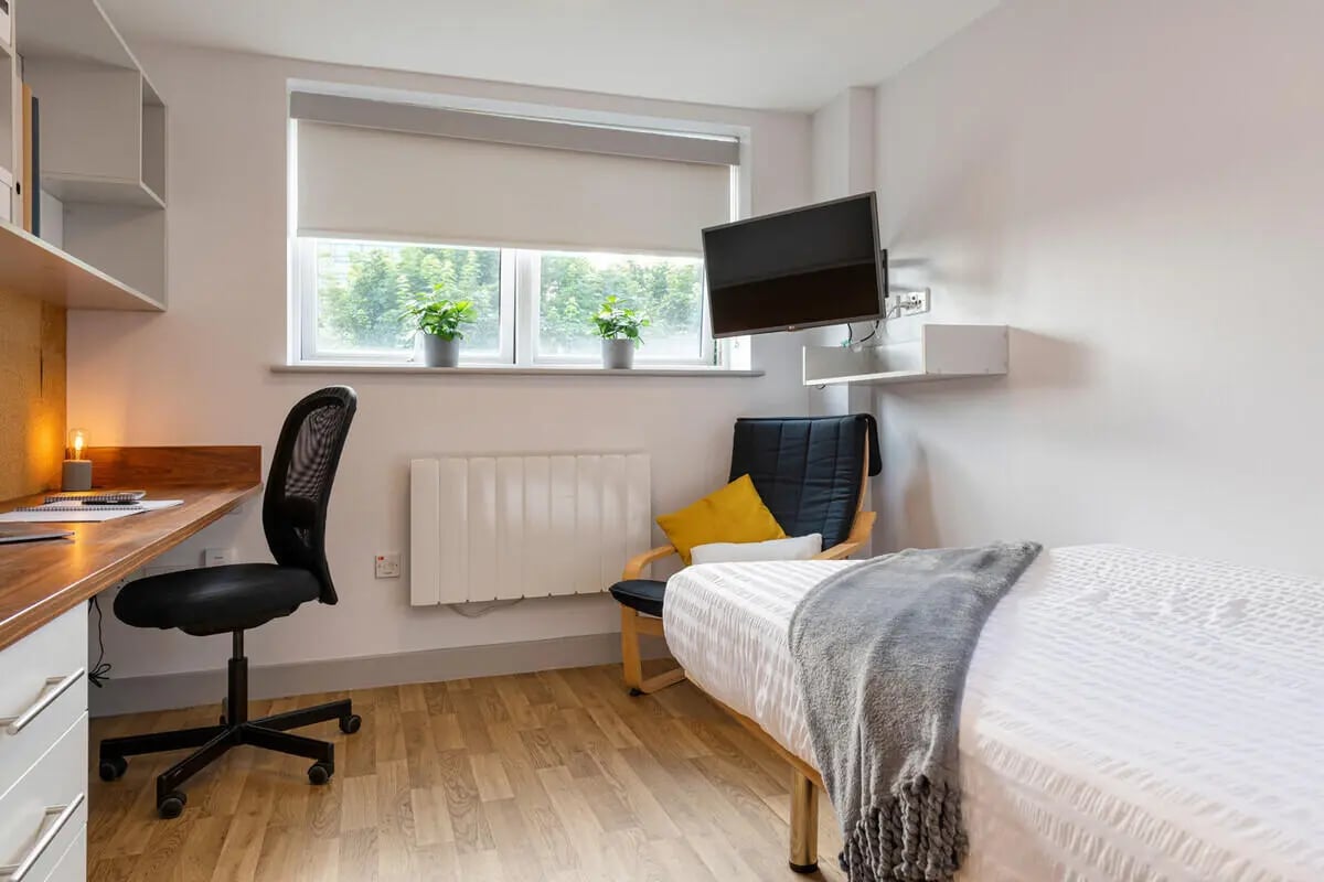 Desk chair bed TV and plants bedroom at Collegiate Earlsdon Street in Portsmouth Student Accommodation