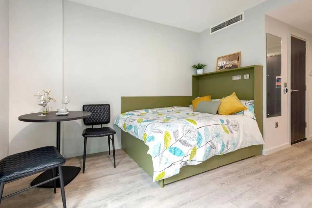 Bed table chairs and desk bedroom at Flora Building - Hoxton in London Student Accommodation