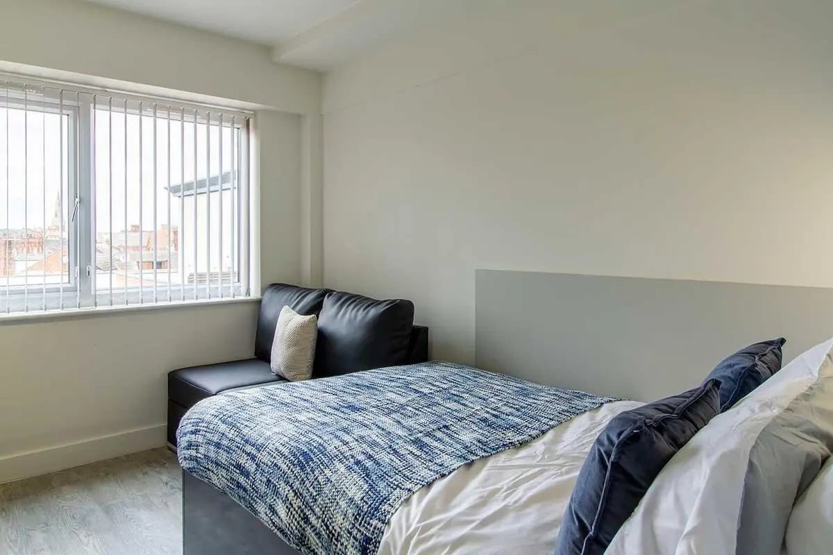 Bed sofa white sheets blue blanket bedroom at Dover Street Apartments in Leicester Student Accommodation