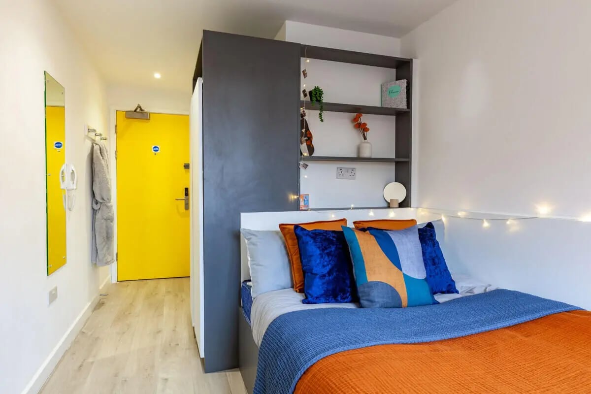 Bed with shelves and yellow door bedroom at Medici in Nottingham Student Accommodation