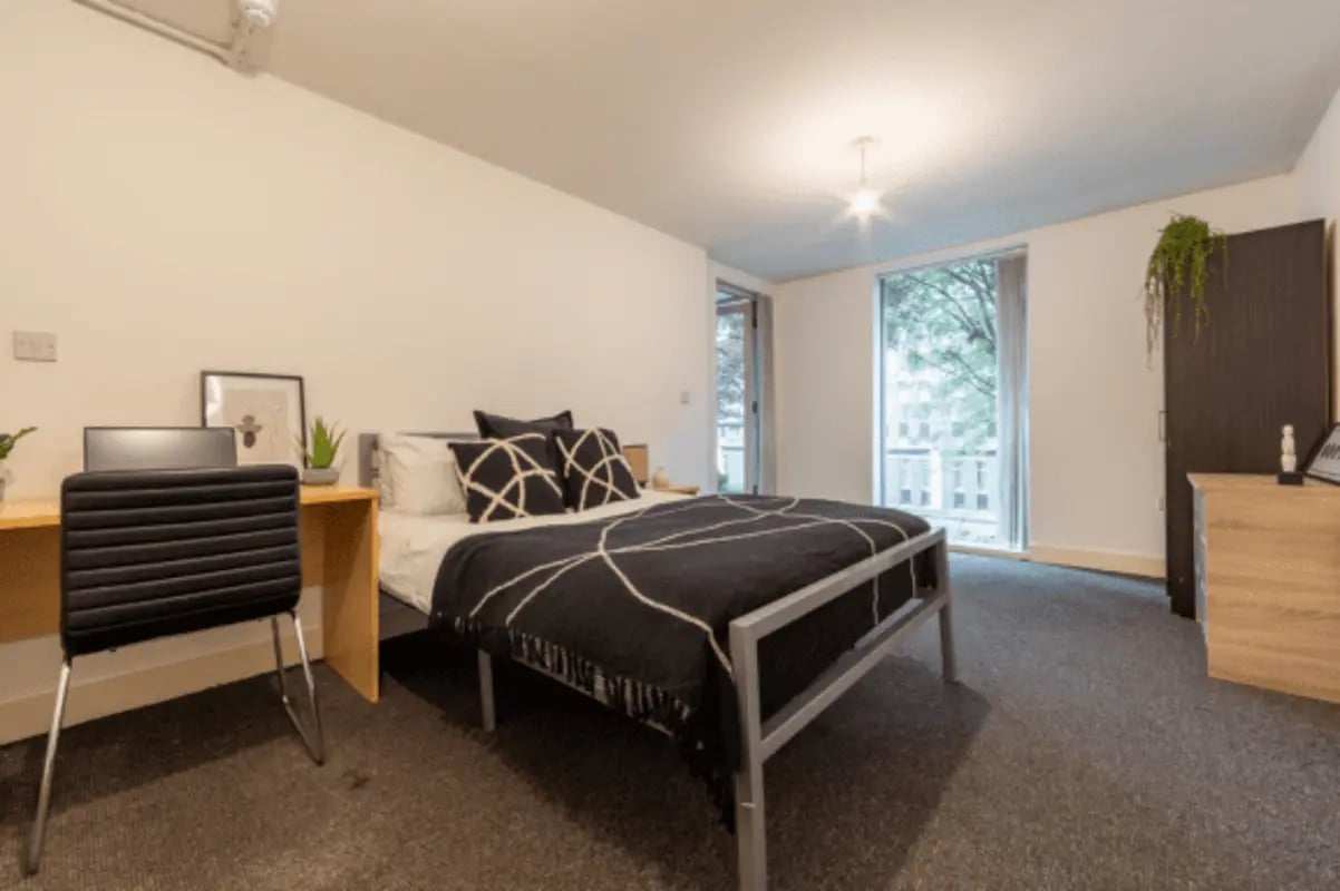 Bed desk chair artwork plants and wardrobe bedroom at The Grafton in Manchester Student Accommodation