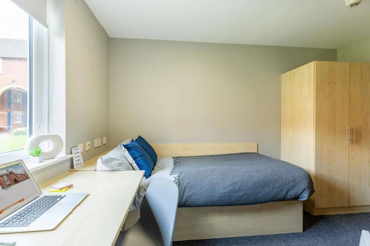 Bed desk laptop wardrobe and pillows bedroom at Calthorpe Court in Birmingham Student Accommodation