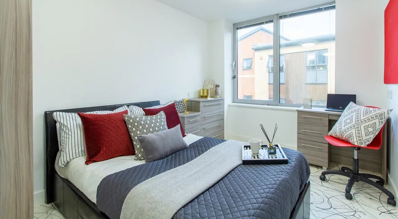 Bed dresser desk chair and laptop bedroom at Queens Gate in Southampton Student Accommodation