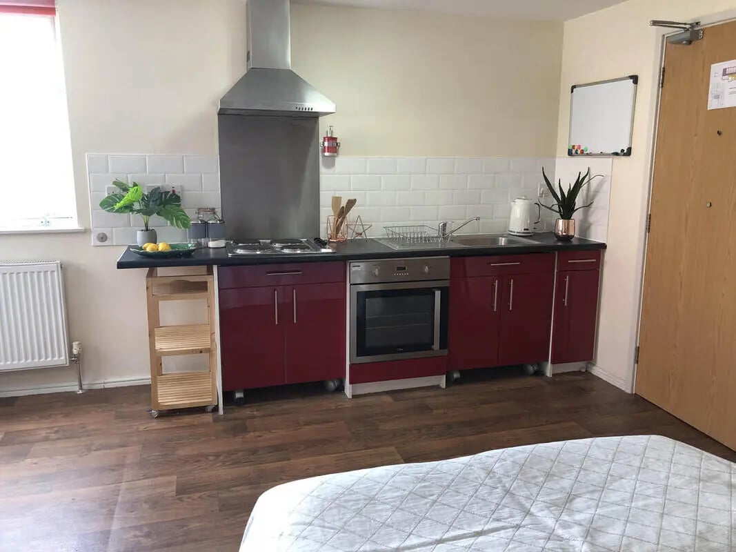 Maroon cabinets oven stovetop sink kitchen at Falkland House in Liverpool Student Accommodation