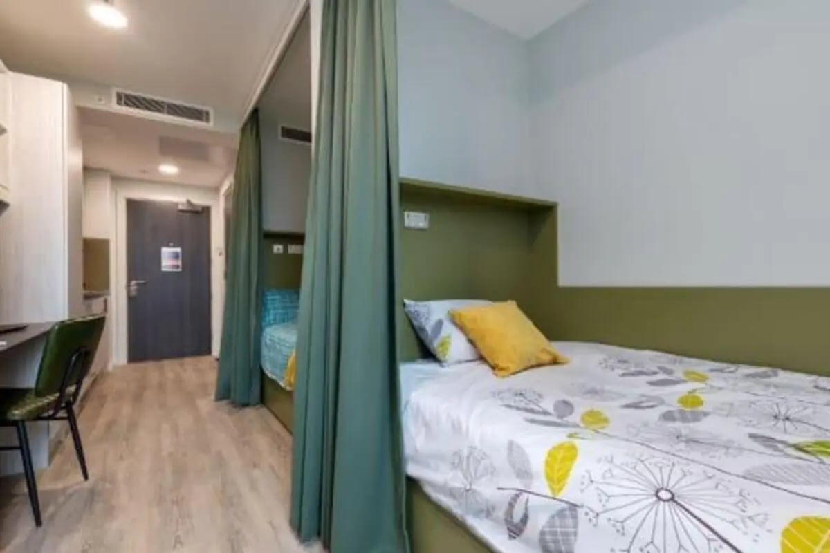 Two beds desk chair and door bedroom at Flora Building - Hoxton in London Student Accommodation