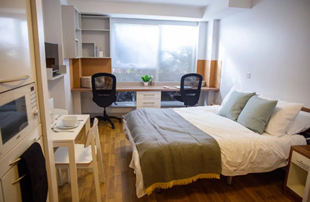 Bed desk chairs microwave and table room at Collegiate Earlsdon Street in Portsmouth Student Accommodation