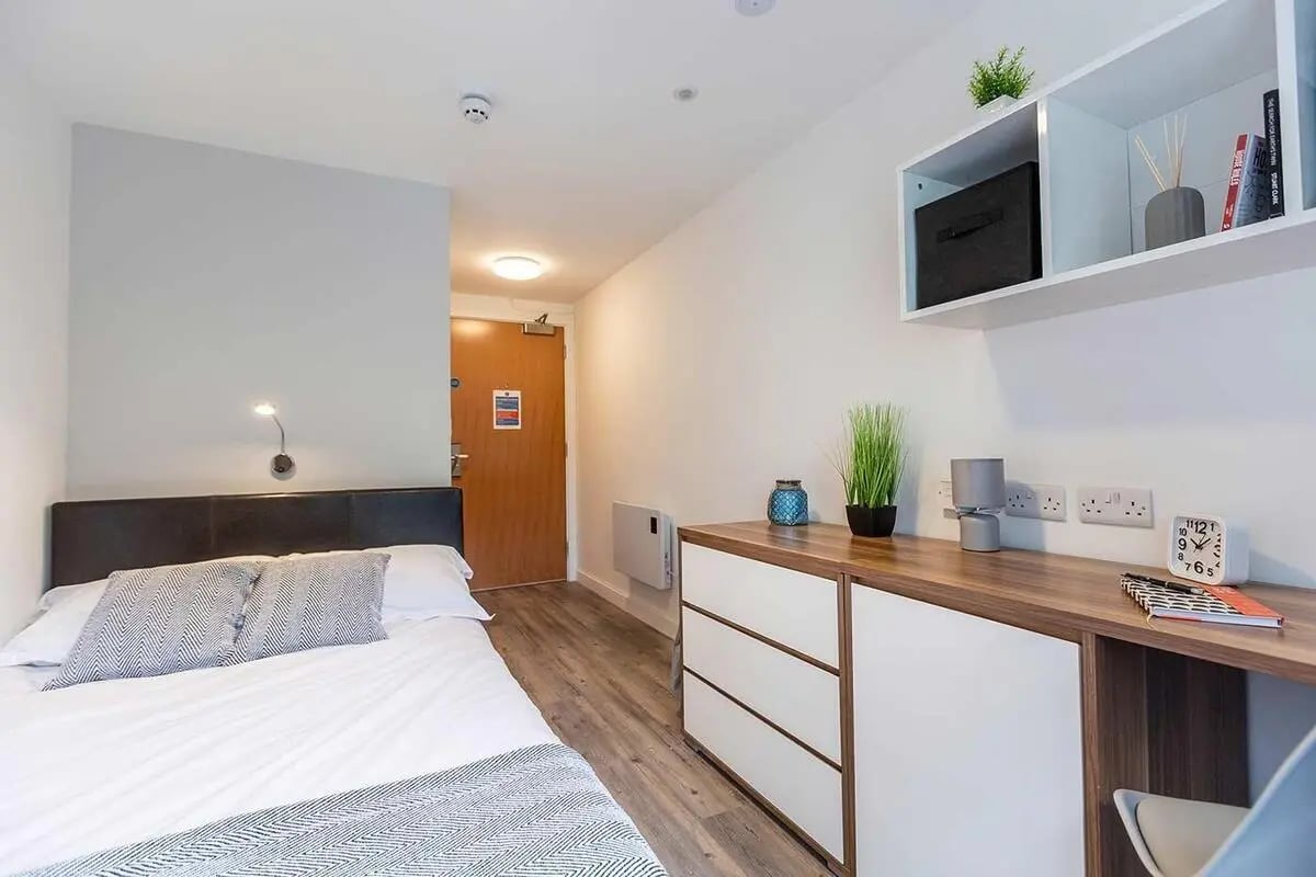 Bed desk dresser and shelves bedroom at Austin Hall in Leeds Student Accommodation