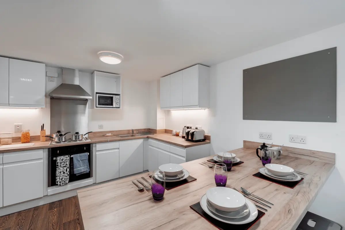 Kitchen table with place settings and modern appliances kitchen at The Old Dairy in Plymouth Student Accommodation