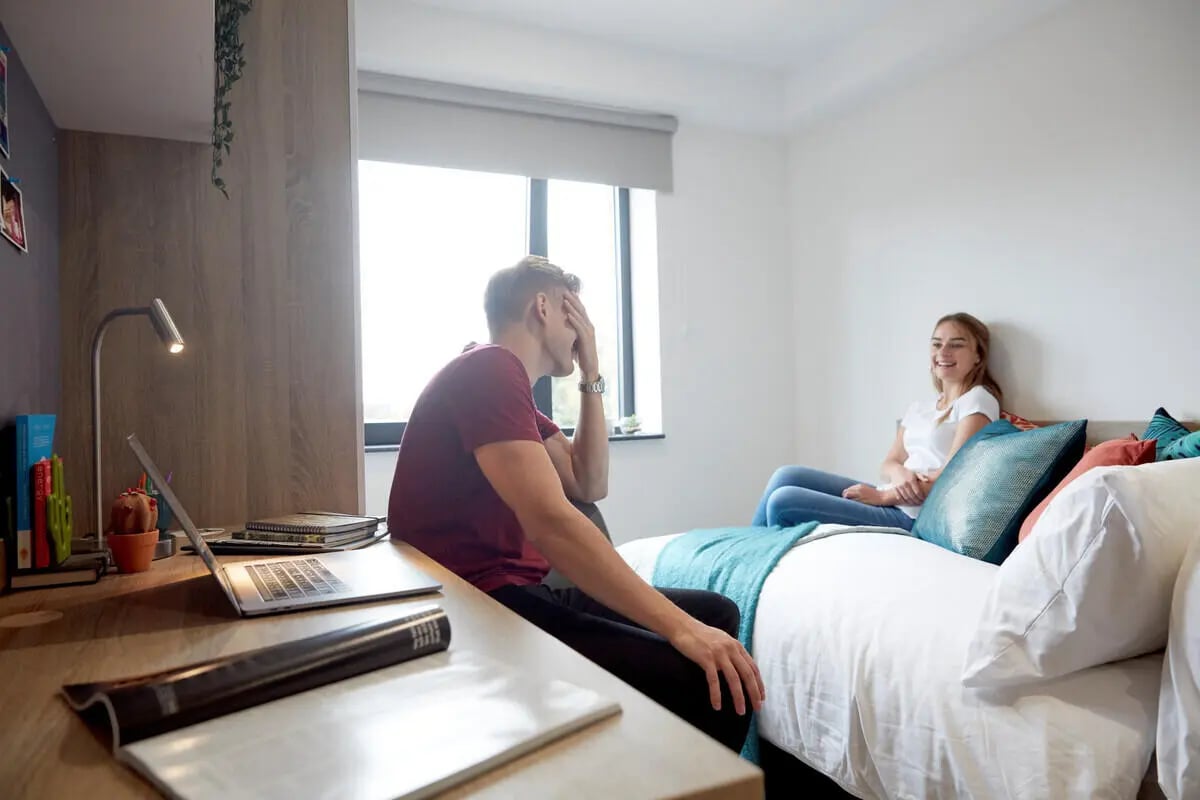 Student bedroom with desk laptop and two people Bedroom at Eden Square in Coventry Student Accommodation