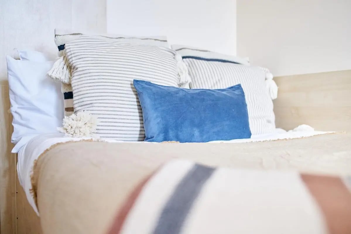 Bed with striped pillows and blue cushion bedroom at Rockingham House in Sheffield Student Accommodation