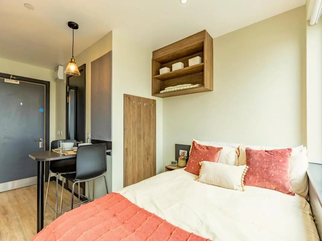 Bed with pillows dining table and chairs Bedroom at Crown House Brighton in Brighton Student Accommodation