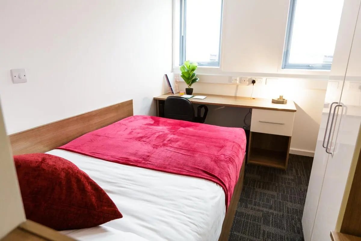 Bed desk chair plant and wardrobe bedroom at AXO Islington in London Student Accommodation