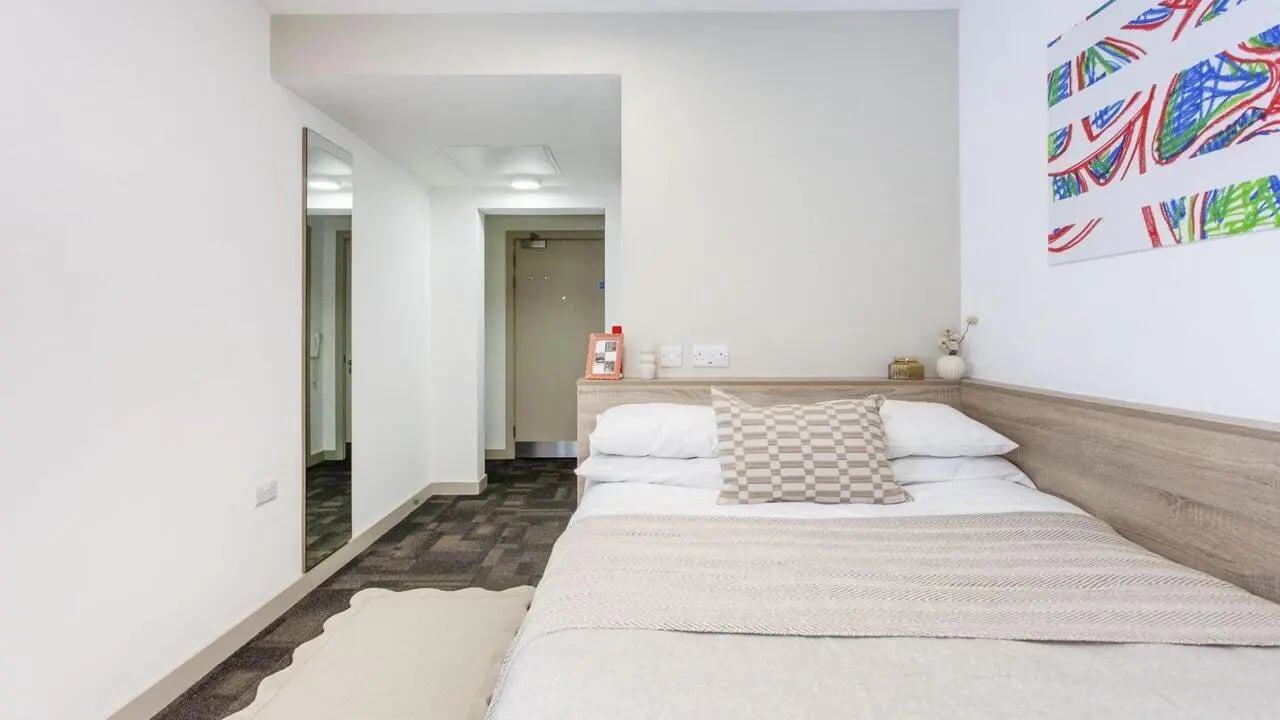 Bed with framed pictures and artwork Bedroom at Berkshire House Reading in Reading Student Accommodation