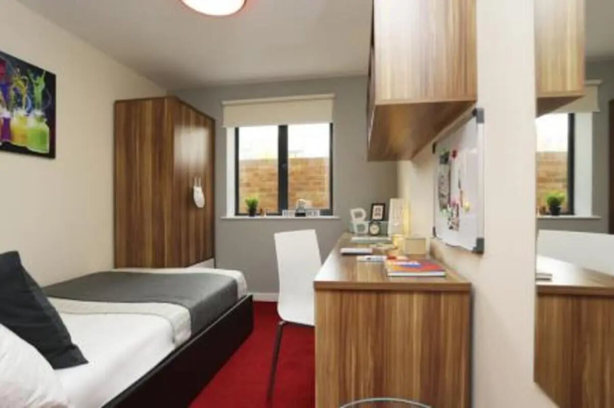 Bed wardrobe desk chair red carpet bedroom at Canterbury Student Village in Canterbury Student Accommodation