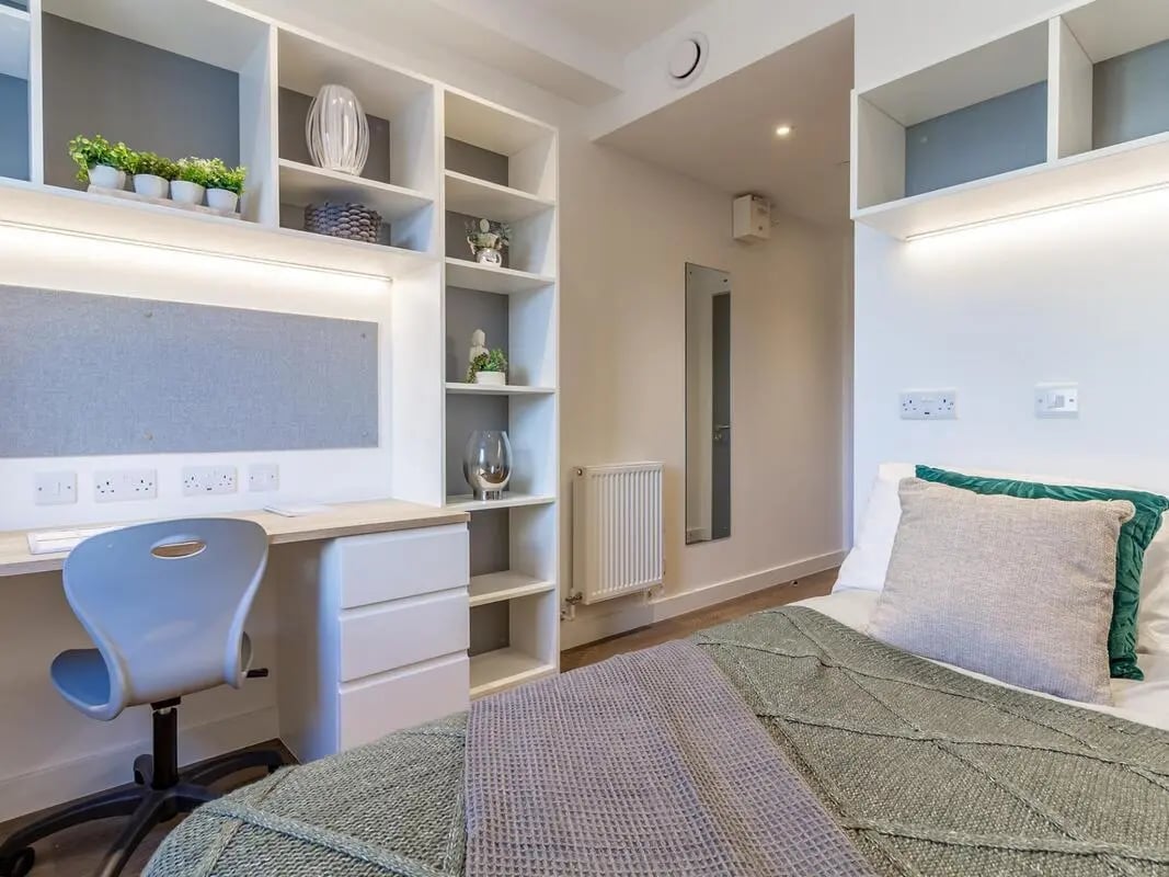 Desk chair shelves plants bed pillows throws bedroom at Saltwater Place in Plymouth Student Accommodation